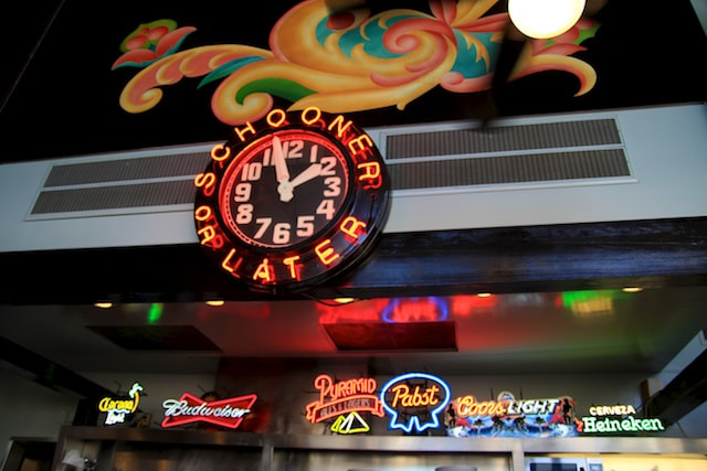 Neon lit beer signs and clock
